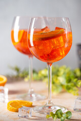 Aperol spritz cocktail in glass with fresh orange on light background