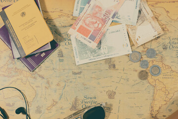 top view of accessories for international travel and travel preparation. passports, vaccination card, sunglasses and coins and bills of the destination. travel concept
