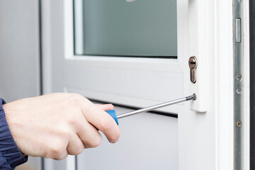 Handyman installing lock in front door. Checking lock for operability.