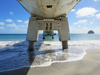 Perspective view of the bottom of a bridge in turquoise sea and tropical blue sky of the French...