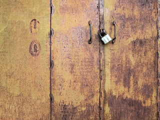 Rusty closed gate. Corrosion of metal in an old garage.