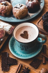 turquoise cup of hot coffee on grey background with cinnamon sticks