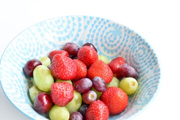 Bowl full of fresh strawberries, grapes and berries