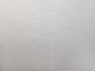 White cardboard background with a wavy bend. Smooth concrete with slight distortion and linear pattern.