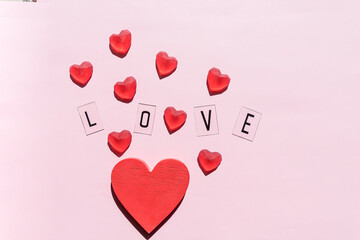 Banner.The word Love.Black letters Love with Red hearts.on pink background.Valentine's day. Loving, positive emotions. Feelings backdrop. Exclusive relationships.