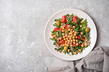 Healthy vegetarian salad with cooked chickpeas, chia seeds, fresh arugula, cherry tomatoes and...