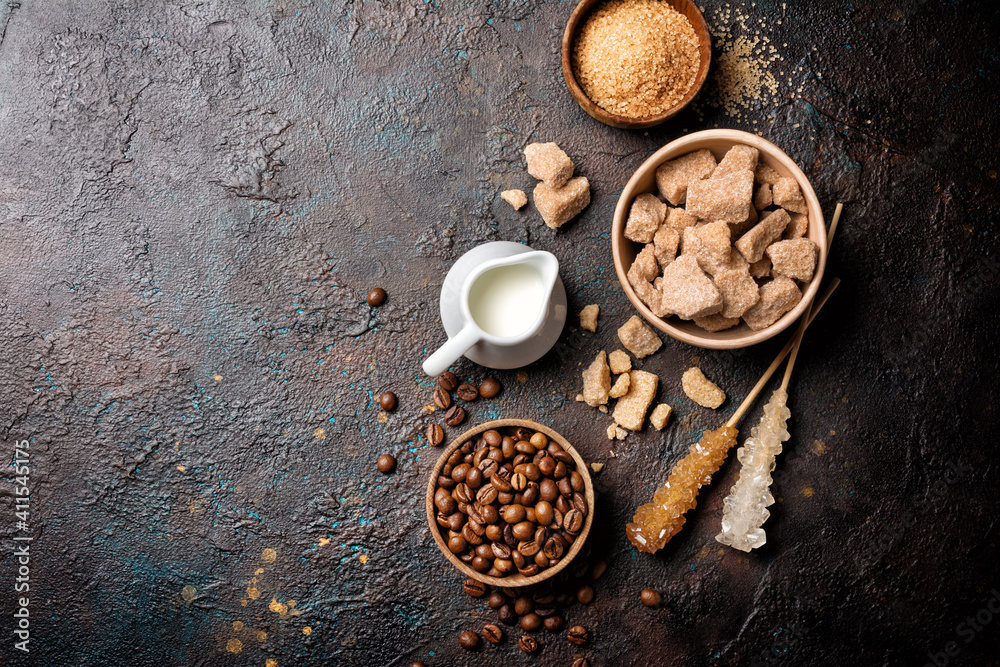 Wall mural Ingredients for coffee drinks. Bowls of brown cane lump and granulated sugar, crystal sugar sticks, milk and coffee beans