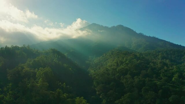 Foggy landscape tropical rain forest jungle island Bali on background majestic volcano Gunung Agung or Mount Agung, located in the district of Karangasem. 4K Aerial view