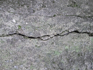 A crack in a concrete slab. Destroyed stone surface. House damage effect.