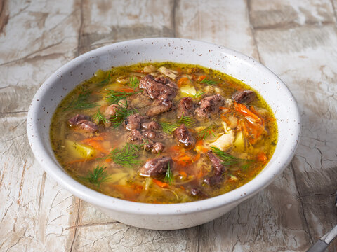 Pickle soup with chicken giblets in a deep plate on the table