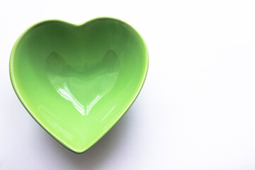 Green empty Heart shaped bowl for healthy eating. Copy space for your text.