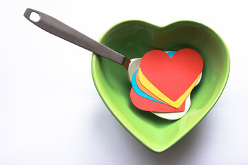 Colorful papers in heart shape inside a heart shaped bowl for valentine's day dinner concept. Top view, copy space for your text.