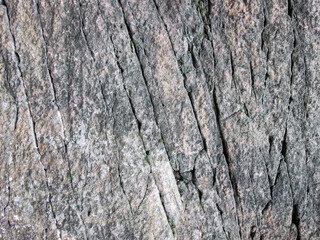 An old rock with cracks and veins. Stock background of ancient stone.