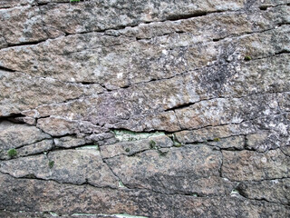 An old cave with layers and cracks. Sandstone deposit. The texture of the destroyed cracked slab.