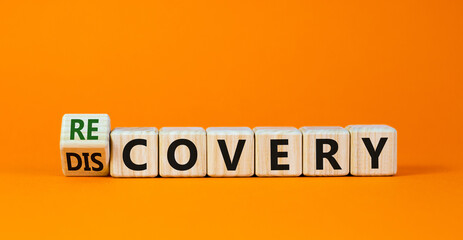 Recovery or discovery symbol. Turned a wooden cube, changed a word 'discovery' to 'recovery'. Beautiful orange background. Business and discovery or recovery concept. Copy space.