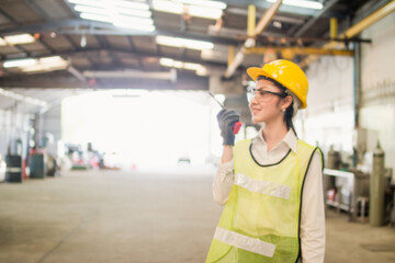 Blured picture foreman engineer woman wear safety helmet standing. Female inspector in helmet with walkie talkie in factory. engineering working in factory concept.