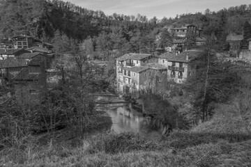 View of the river with old cereal mills in ancient medieval village of Rupit , near Pyrenees , Spain.Travel landscape concept background in black and white style..