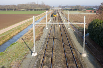 Train in the distance on the railway from above in the Netherlands