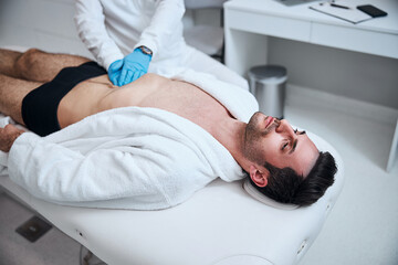 Handsome man being checked up by doctor