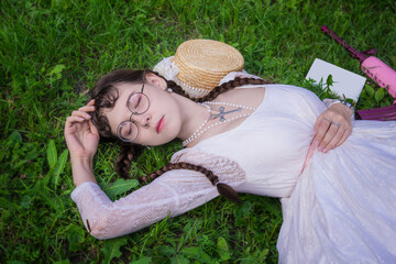 Girl with a book fell a sleep in the park on grass
