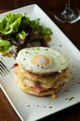 Croque madame or monsieur. Breakfast or brunch favorite: toast, with fried eggs, ham, cheese, and hollandaise sauce. Served with potato hash. Classic French bistro or American restaurant entree.
