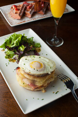 Croque madame or monsieur. Breakfast or brunch favorite: toast, with fried eggs, ham, cheese, and hollandaise sauce. Served with potato hash. Classic French bistro or American restaurant entree.