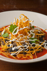 Nachos. Crispy tortilla chips topped with melted cheddar cheese, salsa, meat, black beans, jalapenos, guacamole, sour cream and lettuce. Tex-Mex or Mexican restaurant classic traditional menu item. 
