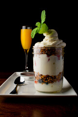 Parfait. Traditional classic breakfast or brunch favorite. Greek yogurt hand rolled granola with dried cranberries and almonds, layered in a jar and served with a classic brunch cocktail a mimosa. 