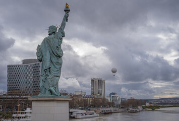 Paris, France - 02 05 2021: View of the Statue of Liberty Paris and a ascension balloon, from Grenelle Bridge during the Seine flood