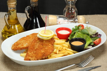 chicken schnitzel with fries and gren salad
