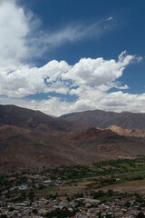 Fototapeta na wymiar View of Humahuaca ravine, the rocky Andes mountains and Tilcara village under a cloudy sky in Jujuy, Argentina.