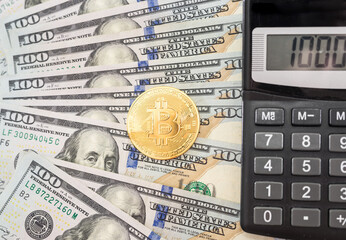 Fototapeta premium bitcoin and calculator on the background of dollars. Gold coin Bitcoin.