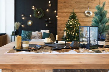 On the eve of the holiday, the interior of the country house is decorated with a New Year tree. large spacious light room decorated with wood with simple wood furniture