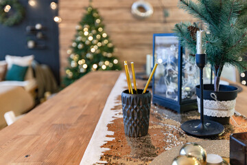 On the eve of the holiday, the interior of the country house is decorated with a New Year tree. large spacious light room decorated with wood with simple wood furniture