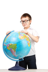 a boy with glasses, an elementary school student, stands next to a globe, an isolate on a white background