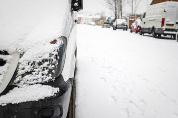 Van parked on british street under winter snow fall in england uk