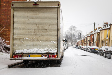 Van parked on british street under winter snow fall in england uk