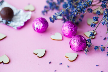 Valentine's day background. row of wooden hearts on a pink background, side view of a branch of dry lavender. Valentine's day concept. Top view, place for an inscription, advertising