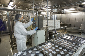 Background image of industrial conveyor belt at clean food production factory with unrecognizable female worker operating machine units, copy space
