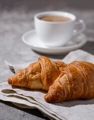 croissants on a gray background and a cup of coffee