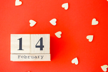 Wooden calendar with the date of February 14 on a bright red background. Romantic date. Valentine's...