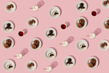 Creative pattern made of cookies, biscuits, milk, tea and coofee on pink background. Morning rituals, messy breakfast table.