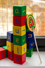 blocks spell out the word "abuela" with a lollipop
