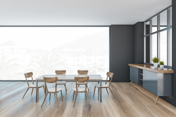 Grey and wooden living room with chairs and table, window with palms