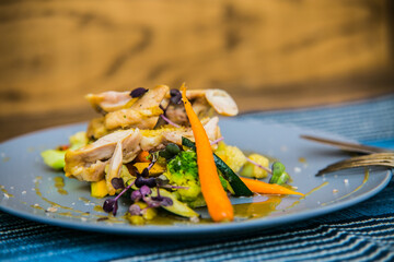 Chicken thigh on roasted vegetables on plate. The food in the restaurant. Food styling and restaurant meal serving.