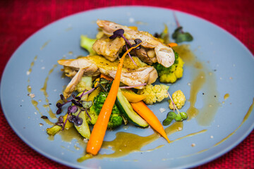 Chicken thigh on roasted vegetables on plate. The food in the restaurant. Food styling and restaurant meal serving.
