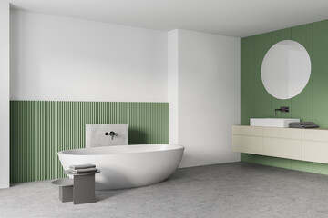 Fototapeta na wymiar White and green bathroom with white bathtub, mirrors and marble floor