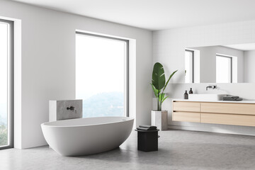 Fototapeta na wymiar Interior of stylish bathroom with wooden walls, concrete floor, comfortable bathtub, double sink with horizontal mirror.