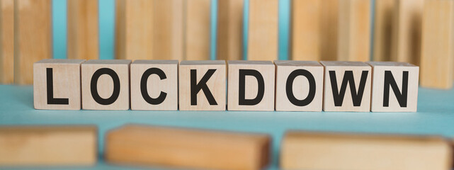 LOCKDOWN word written on wooden blocks on light blue background.