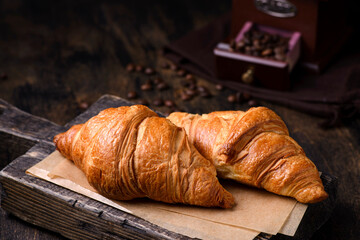 croissants on a wooden board on a brown background